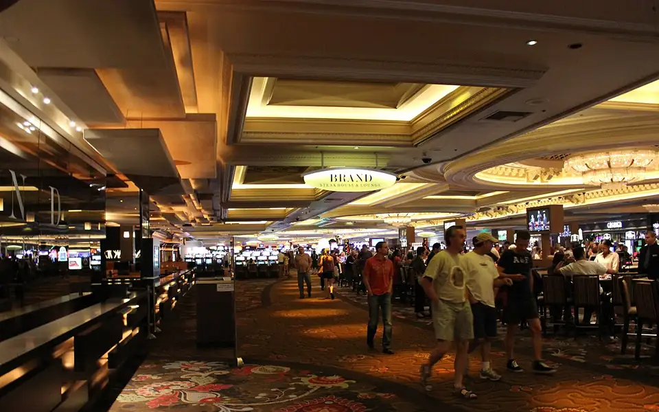 Crowd of players walking through a brightly lit casino gaming floor